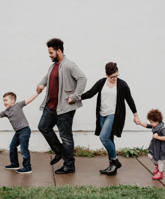 Family happily walking while holding hands